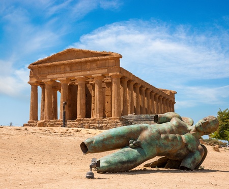 Concordia temple with beautiful sky and statue of angel in front  in the Valley of the Temples, Agrigento, Sicily island, Italyの写真素材