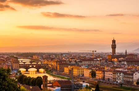 Golden sunset over the river Arno, with Ponte Vecchio and Palazzo Vecchio, Florence, Italyの写真素材