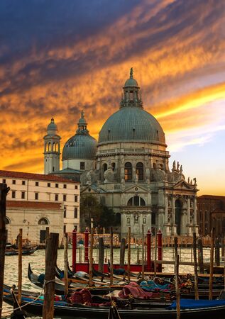 Dramatic sunset over Grand Canal and Basilica Santa Maria della Salute with gondolas in front, Venice, Italyの写真素材
