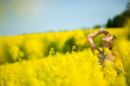 girl in a scarf in a raps field in summerの写真素材