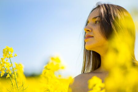 country girl in a raps field in summerの写真素材