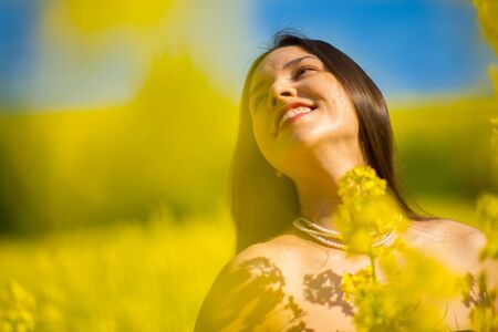 country girl in a raps field in summerの写真素材