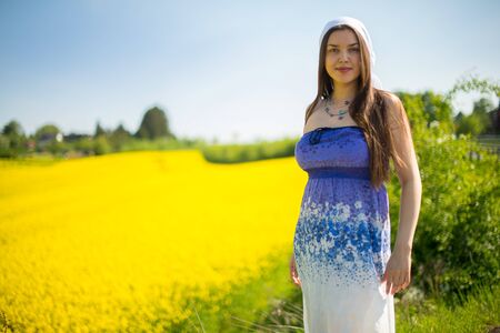girl in a scarf in a raps field in summerの写真素材