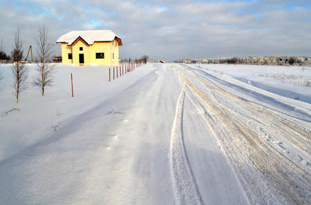 road to the house in winter landscapeの写真素材