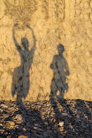 shade loving couple on a rocky beachの写真素材