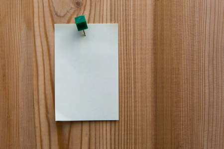 yellow sticky note on a wooden backgroundの写真素材