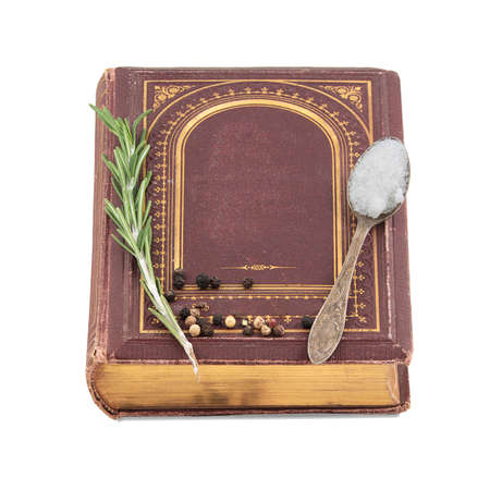 Old cookbook with spices isolated on a white backgroundの写真素材