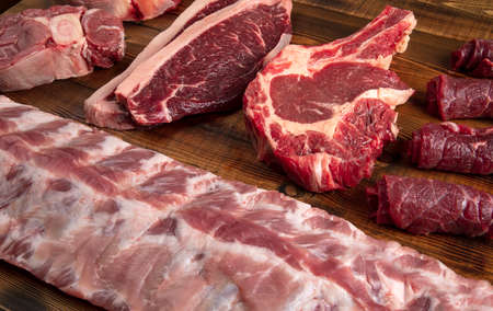 Pieces of meat of different types on the board. Beef and pork.の写真素材