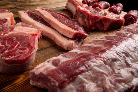 Pieces of meat of different types on the board. Beef and pork.の写真素材