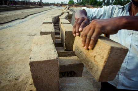 AMRITSAR, PUNJAB, INDIA - APRIL 2017 : a worker sorting the bricks for dispatching at a brick making...