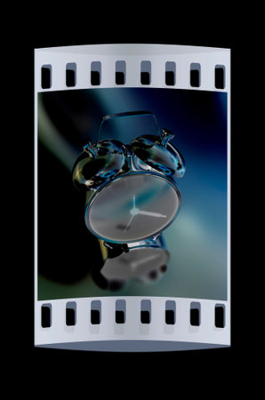 Alarm clock on a black background. The film strip