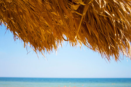 Beach and sun straw umbrella on the beachの写真素材