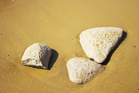 Trinity stones on seashore at sun - sand, stone and relaxationの写真素材