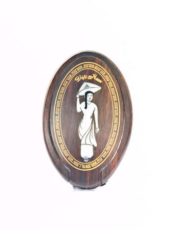 A vietnamese girl in traditional uniform pattern on the cover of wooden cosmetic mirror isolated on backgroundの写真素材