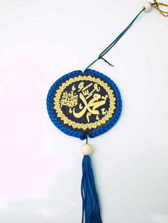 A blue velvet Allah pendent isolated on white background Islamic calligraphy transliterated as 