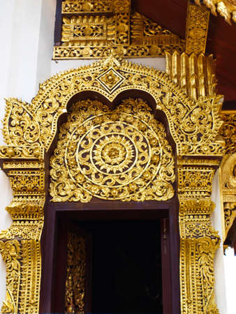 Closeup of golden wooden carving entrance gate, Wat Phrathat chomkitti temple in Chiang rai, Thailand の写真素材