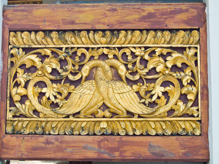 golden wooden carving of peacocks, Wat Phrathat chomkitti temple in Chiang rai, Thailand の写真素材