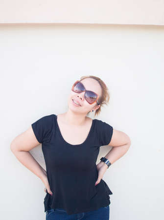 Young Asian lady wearing sunglasses smiling in natureの写真素材