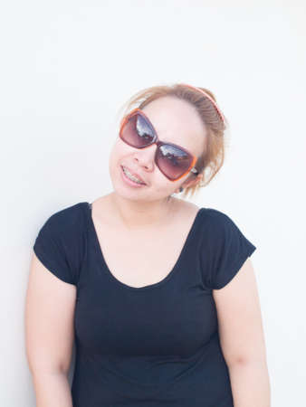 Young Asian lady wearing sunglasses smiling in natureの写真素材