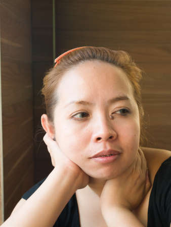 Curious young Asian lady looking on something in natureの写真素材