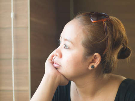 Curious young Asian lady looking on something in natureの写真素材