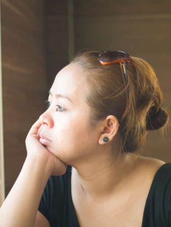 Curious young Asian lady looking on something in natureの写真素材