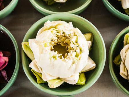 Thai traditional  folded white and pink lotus  in small green ceramic bowls for paying homage to hindu godsの写真素材