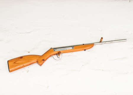 vintage old western wooden rifle hanged on white wallの写真素材