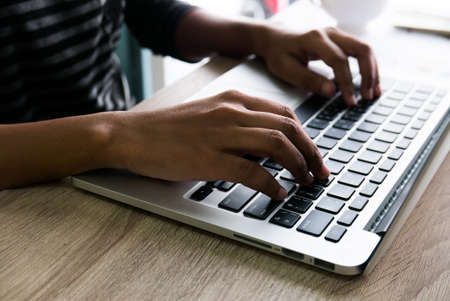 Asian female office worker typing on her laptopの写真素材