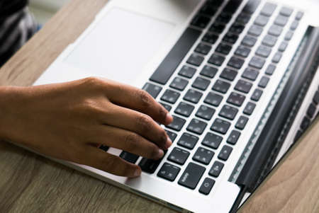 Asian female office worker typing on her laptopの写真素材