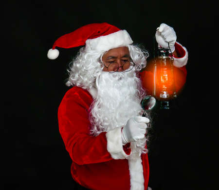 Santa Claus holding lantern for lighting studio shot on black background for family, giving, season, Christmas, holiday, new year, travel, Christian and gathering conceptの写真素材
