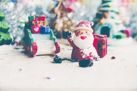 Santa Claus, snowman, houses & snow Sledge miniature model studio shot on colorful background for family, giving, season, Christmas, holiday, new year, travel and gathering conceptの写真素材