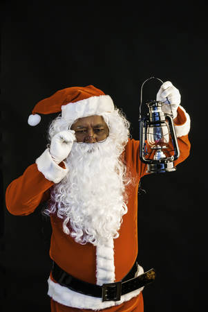 Santa Claus holding lantern for lighting studio shot on black background for family, giving, season, Christmas, holiday, new year, travel, Christian and gathering conceptの写真素材