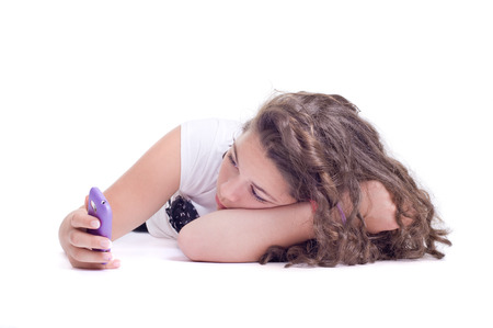 Teenage girl with cellphone  Isolated on a white background  Studio shotの写真素材