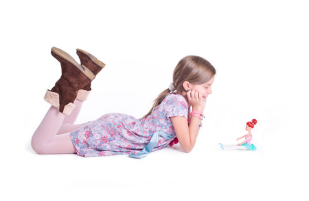 Sweet little girl posing with her doll の写真素材