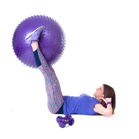 Sport woman exercising with a purple pilates ball and dumbbells  Isolated on a white background  Studio shotの写真素材
