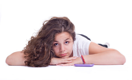 Teenage girl with mobile telephone  Isolated on a white background  Studio shotの写真素材
