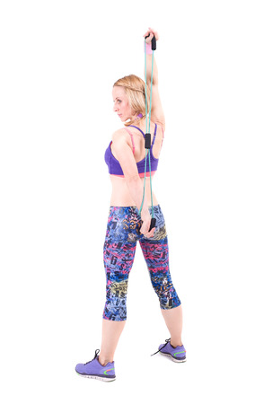 Young sporty woman exercising with a resistance rope  Isolated on a white background  Studio shotの写真素材