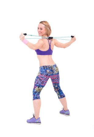 Young sporty woman exercising with a resistance rope  Isolated on a white background  Studio shotの写真素材