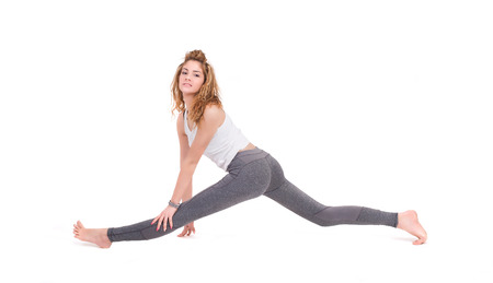 Sport young woman doing fitness exercise  Isolated on a white background  Studio shotの写真素材