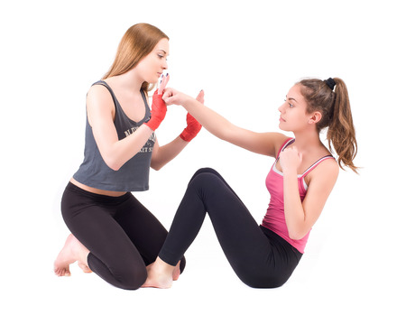 Two young women practicing in studio  Isolated on a white background  Studio shotの写真素材