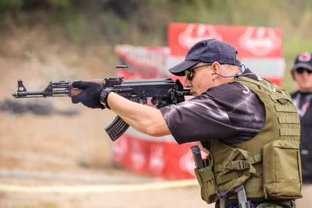 Man with Submachine Gun Shooting in Weapons Training, Outdoor Shooting Rangeの写真素材