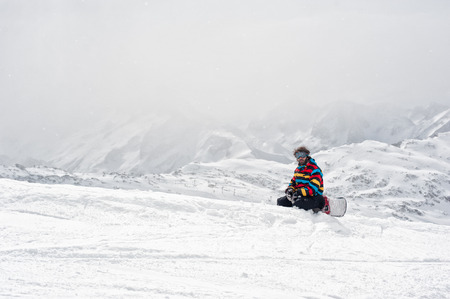 Snowboarder sit at top of mountain Winter Scenic in the French Alps, Les 2 Alpesの写真素材