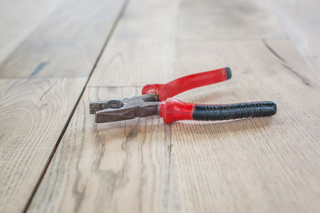 Pliers on the wooden table Old red pliers on the wooden tableの写真素材