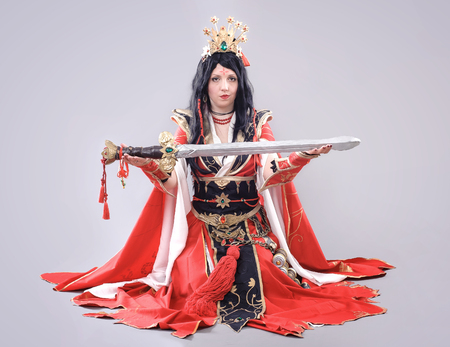 Wizard. Model dressed in renaissance style on gray backgroundの写真素材