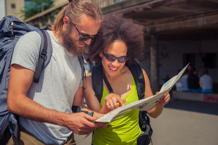 Young beautiful happy couple looking on touristic map in Belgrade