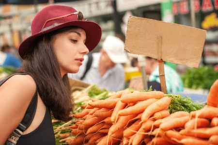 A young woman buying fruits and vegetables at a weekly market.の写真素材