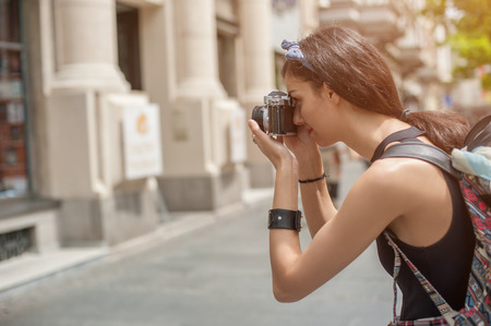 Pretty young female tourist taking pictures in the cityの写真素材