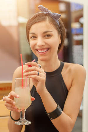 Gorgeous young brunette drinking lemonade, summer heat refreshmentの写真素材