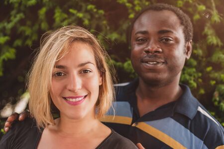 Outdoor portrait of romantic and happy international young couple in parkの写真素材